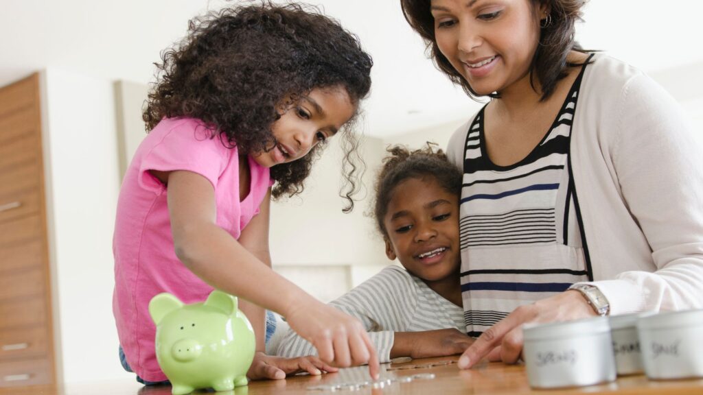 Mother teaching children how to count money from piggy bank